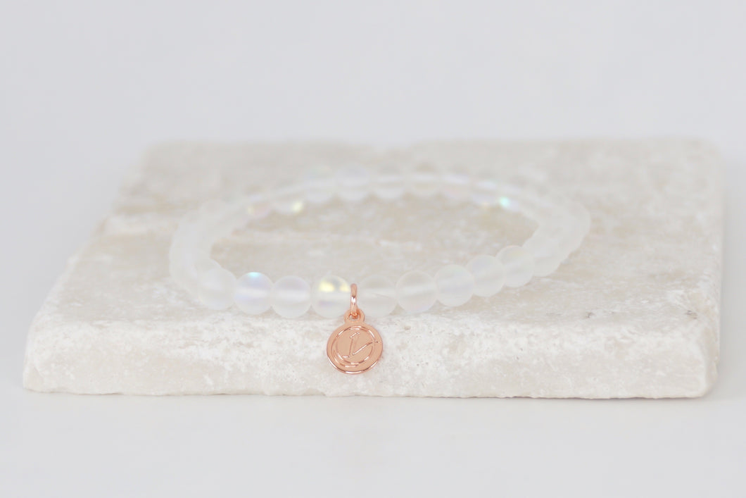 White moonstone bracelet on elastic with rose gold tag